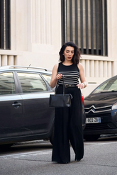 a lady in a black striped tank top and a pair of black wide leg pants